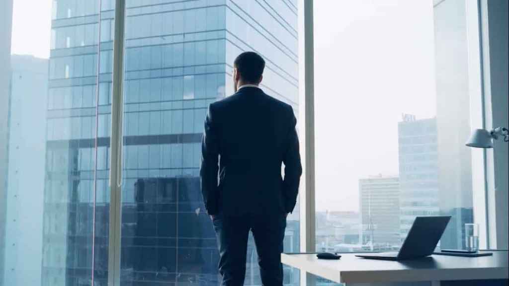 مستثمر عقاري يفكر بعمق في مخاطر وتحديات السوق من نافذة مكتبه