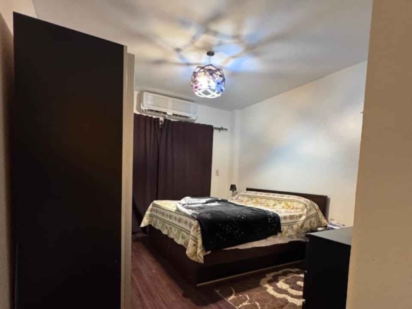 غرفة نوم مكيفة بفرش مودرن في شقة للبيع بمدينتي B3.