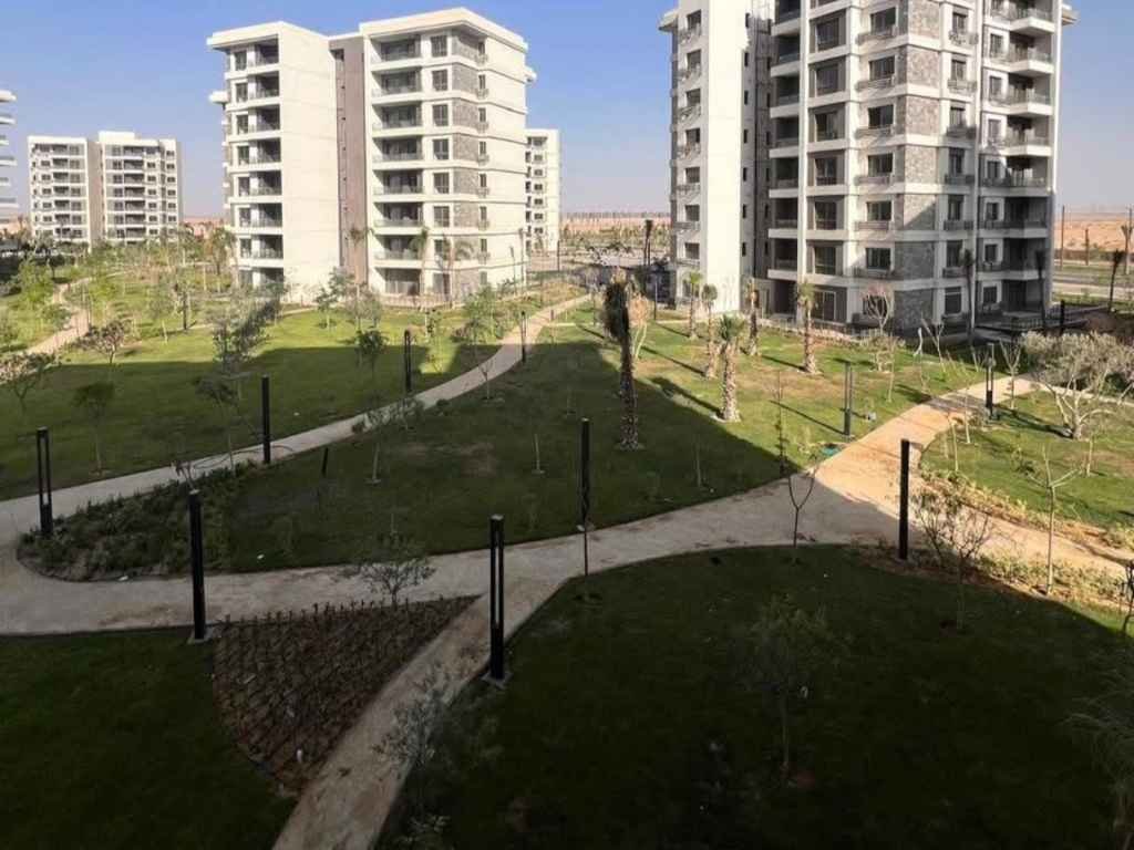 صورة من الشباك توضح الإطلالة البانورامية على الوايد جاردن لشقة 176م حجز الافتتاح للبيع في مدينة نور، مقدمة من تايكون العقاري.